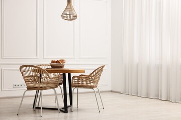 Wall Mural - Dining room interior with wooden table and wicker chairs. Space for text