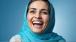 young middle eastern elderly woman on plain bright blue background laughing hysterically looking at camera background banner template ad marketing concept from Generative AI