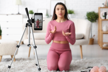 Sticker - Female sports blogger recording video on screen of mobile phone at home, closeup