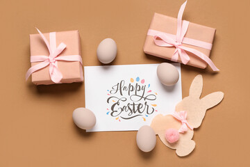 Sticker - Greeting card with text HAPPY EASTER, eggs, paper bunny and gift boxes on brown background