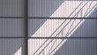 Gray corrugated steel wall background on metal structure inside of new warehouse building in under construction with light and shadow on surface