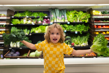 Wall Mural - Child with lettuce chard vegetables. Kid choosing food in grocery store or a supermarket. Fruit and vegetable.