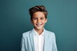 Portrait of a cute little boy in a suit on a blue background