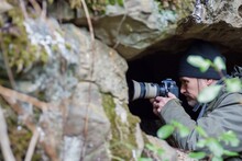 Birdwatcher With A Camera In A National Park Hideout