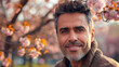 © Keitma - Portrait of an handsome South American hispanic man posing in front of a blooming cherry tree , close-up view of a cheerful beautiful latino white middle aged male in an outdoor park