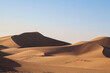© Cavan Images - High desert sand dune two peoples on top in the distance