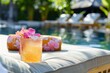 cocktail with floral garnish on a poolside lounger