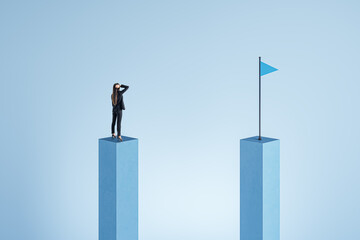 Canvas Print - Side view of young businesswoman on concrete bar looking at blue flag. Strategy, forecast and goal concept.