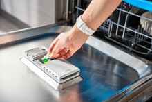 Woman Hand Putting Detergent, Multifunction Tablet Into Dishwasher. Household Chores, Duties With Modern Kitchen Appliance.