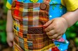visible chocolate bar in the pocket of a childs colorful overalls