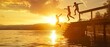 The silhouettes of kids jumping off the dock on the lake at sunset.