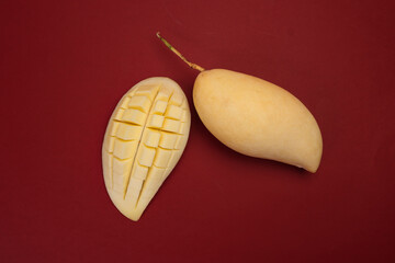 Canvas Print - Yellow mango tropical fruit whole sliced cube diced half on red background