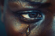 a black woman's eye shedding tears, sadness and conveying concepts related to mental health and being a victim of gender violence.