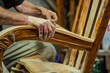 artisan sanding a curved armrest on a wooden rocking chair