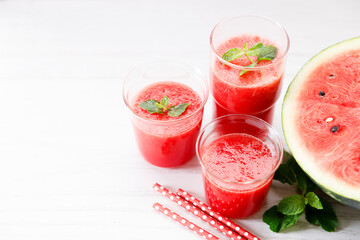 Wall Mural - Glass of fresh watermelon smoothie covered with mint leaves.