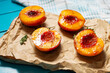 Baked peaches with honey and cinnamon on blue wooden background. summer dessert.