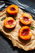 Baked peaches with honey and cinnamon on black stone background. summer dessert.