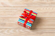 Wrapped christmas or other holiday handmade present in paper with colored ribbon. Present box, decoration of gift on table, top view with copy space