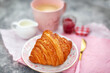 Dellicious croissant, jam and espresso coffee for breakfast, pink and gray background, close-up, soft focus