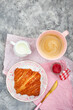 Dellicious croissant, jam and espresso coffee for breakfast, pink and gray background, top view