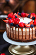 Delicious homemade Three chocolate mousse cake decorated with fresh berries