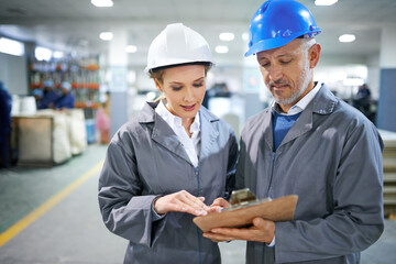 Aufkleber - Man, woman and conversation with clipboard in factory for quality inspection or safety checks and process monitoring. Team, communication and board for manufacturing information in printing warehouse