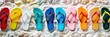 Colorful display of flip-flops arranged in a rainbow spectrum against a backdrop of white sand and seashells, capturing the essence of summer footwear created with Generative AI Technology	