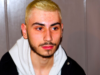 closeup of caucasian boy with beard and bleached hair