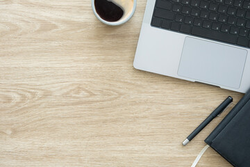 Wall Mural - Top view laptop, notepad and cup of coffee on wooden table with copy space for text.