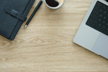 Wall Mural - Top view laptop, notepad and cup of coffee on wooden table with copy space for text.