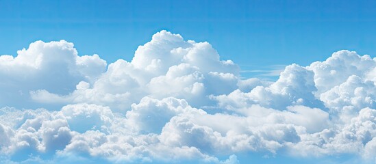 Canvas Print - White cumulus clouds gently float in a bright blue sky creating a picturesque scene of tranquility and calm