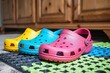 brightlycolored crocs lined up on floor mat