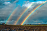 Fototapeta Tęcza - Rainbow After Spring Rain with Thunder: The Emergence of Sun and Clearing Rain Clouds Symbolizing the Changeable Weather of Spring
