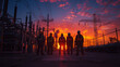 A group of workers in high-visibility vests stand silhouetted against a dramatic sunset in an electric power grid.
