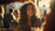 © Adobe Contributor - Portrait of a smiling young woman with curly hair sitting at a restaurant with friends