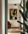 A framed artwork hanging on the wall of an apartment, featuring abstract shapes and vibrant colors, creating visual interest in a minimalist interior design style.