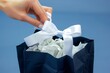 hands placing a white bow on top of a navy gift bag filled with tissue