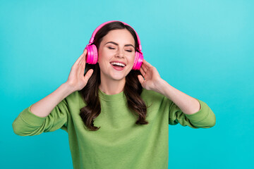 Wall Mural - Photo of overjoyed satisfied girl closed eyes hands touch headphones isolated on turquoise color background