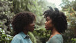 © sommersby - Two women face each other, intimately conversing amidst vibrant greenery