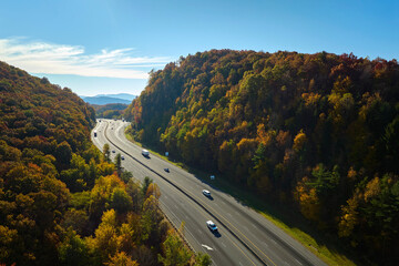 Poster - I-40 freeway road leading to Asheville in North Carolina thru Appalachian mountains with yellow fall forest and fast moving trucks and cars. Concept of high speed interstate transportation