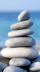 Wall Mural - Zen meditation background - balanced stones stack cairn close up on sea beach