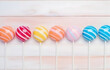 colorful striped lollipops on white wooden table for holiday gre