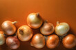 Onions on orange background, close up.