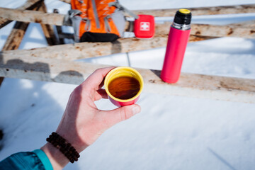 Sticker - Man drinking hot tea outdoors in cold season, man holding mug in front of him, warming drink in forest.