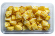 Pineapple pieces inside transparent retail box isolated on white background. Top down view on plastic container with juicy peeled fruit shreds.
