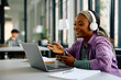 © Drazen - Happy black female student making video call via laptop at university.
