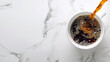 Coffee stream from above filling white cup, placed against marble background. Black coffee espesso