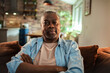 © Marko Geber - Portrait of a senior African American man sitting on the couch at home