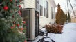 Outdoor air conditioning unit at home in winter - Residential outdoor air conditioner unit installed outside a home with snow on the ground and a festive atmosphere