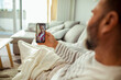 © Davor - Man video calling smiling young woman on smartphone at home